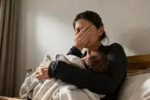 Traurige Mutter mit einem Neugeborenen